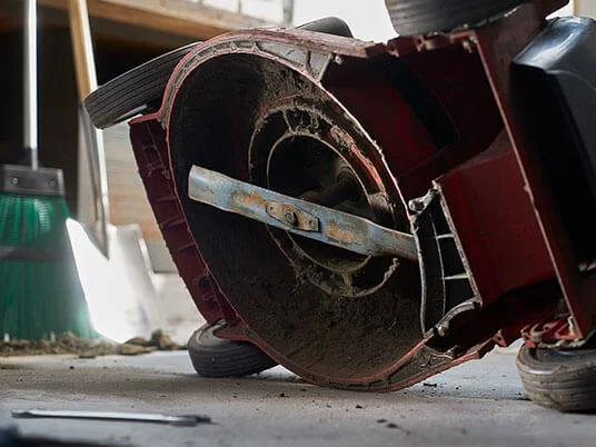 Umazana kosilnica obrnjena na glavo, vidno rezilo