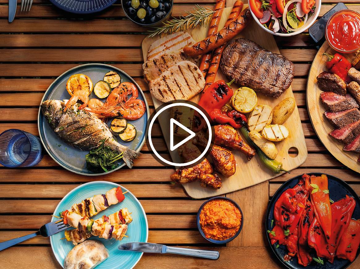 Piknik miza s pestro izbiro žara: ribe, morski sadeži, meso, zelenjava in omake.