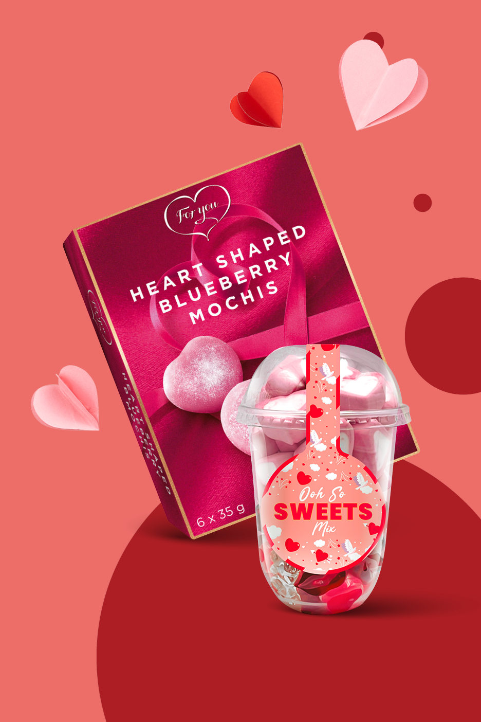 Škatla srčastih močijev in skodelica sladkarij na rdečem ozadju z dekoracijo src.