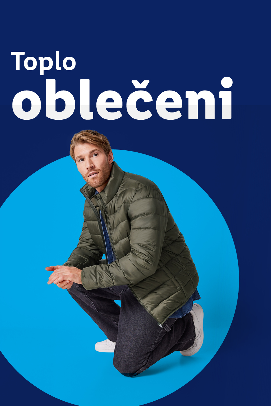 Moški v zeleni prešiti jakni in kavbojkah, s sloganom 'Toplo oblečeni'.