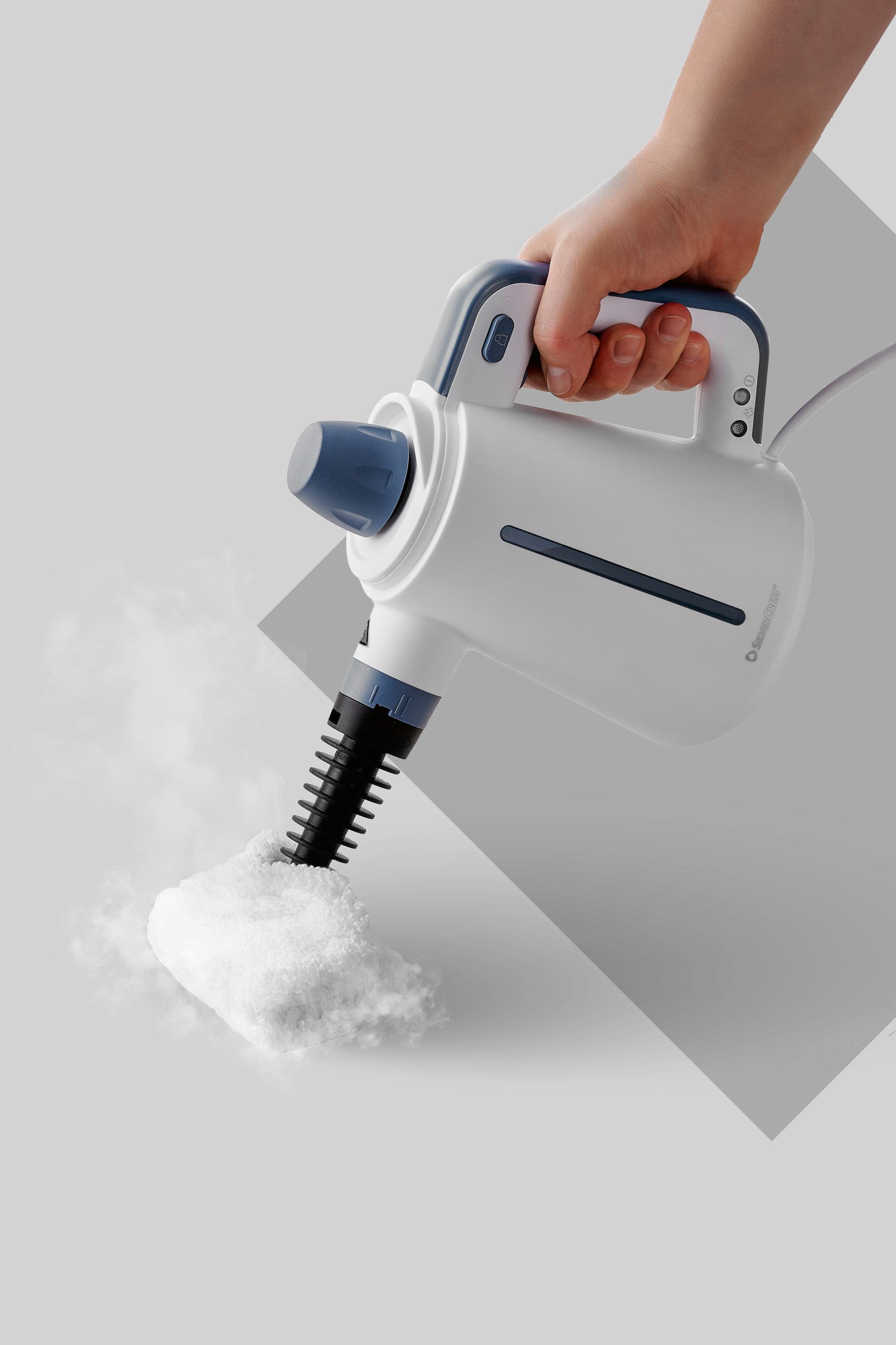 Ročni parni čistilnik s paro, ki čisti belo krpo.