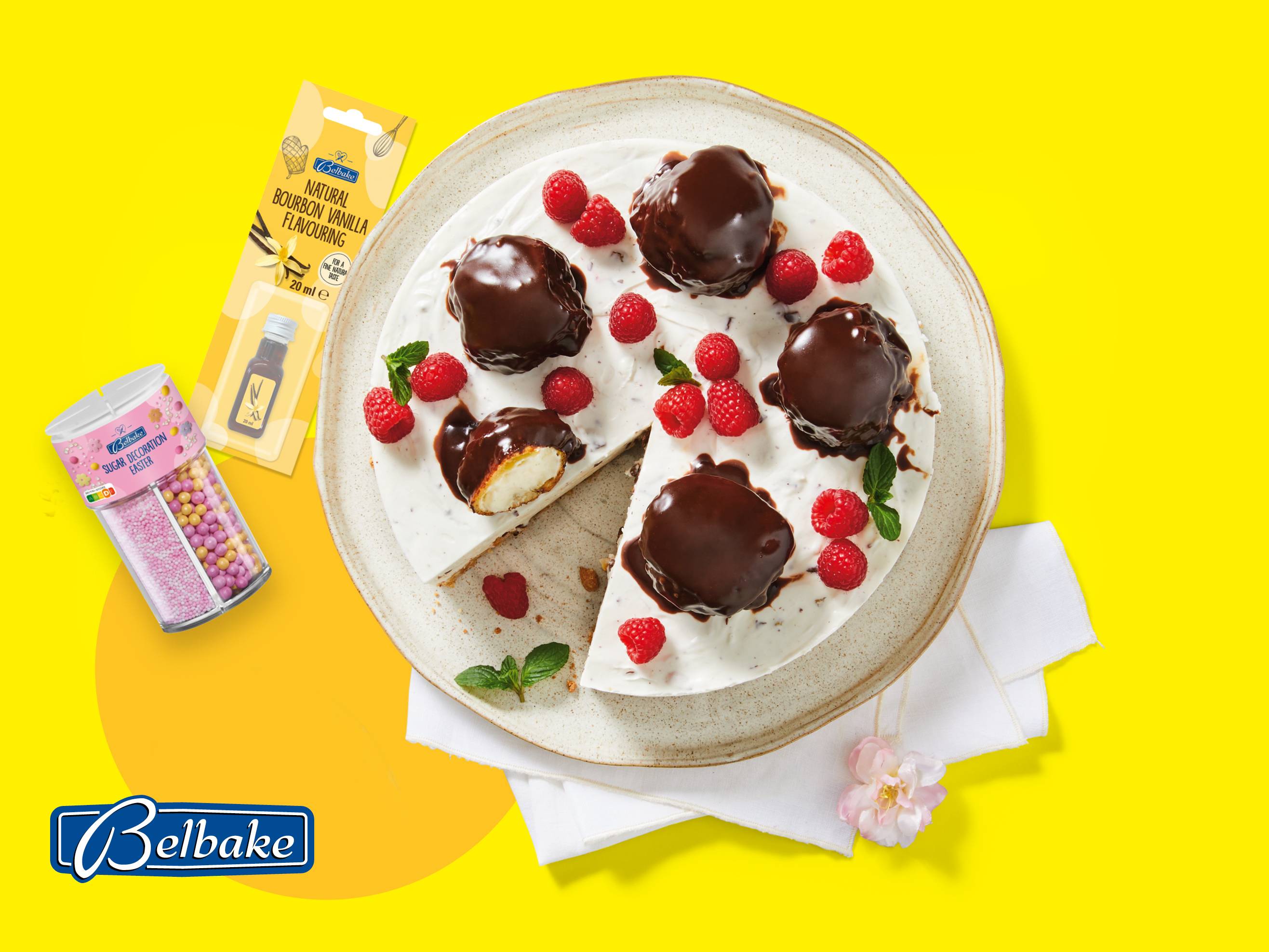 Sladica z vanilijevo aromo in posipi, okrašena z malinami in čokolado.