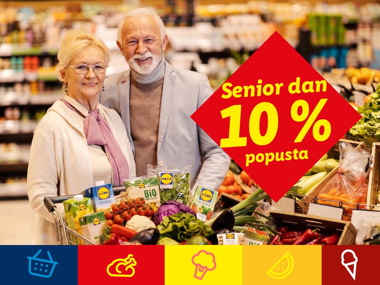 Nasmejan starejši par v trgovini z vozičkom polnim sveže zelenjave in pijač, obvešča o 10% popustu za seniorje.