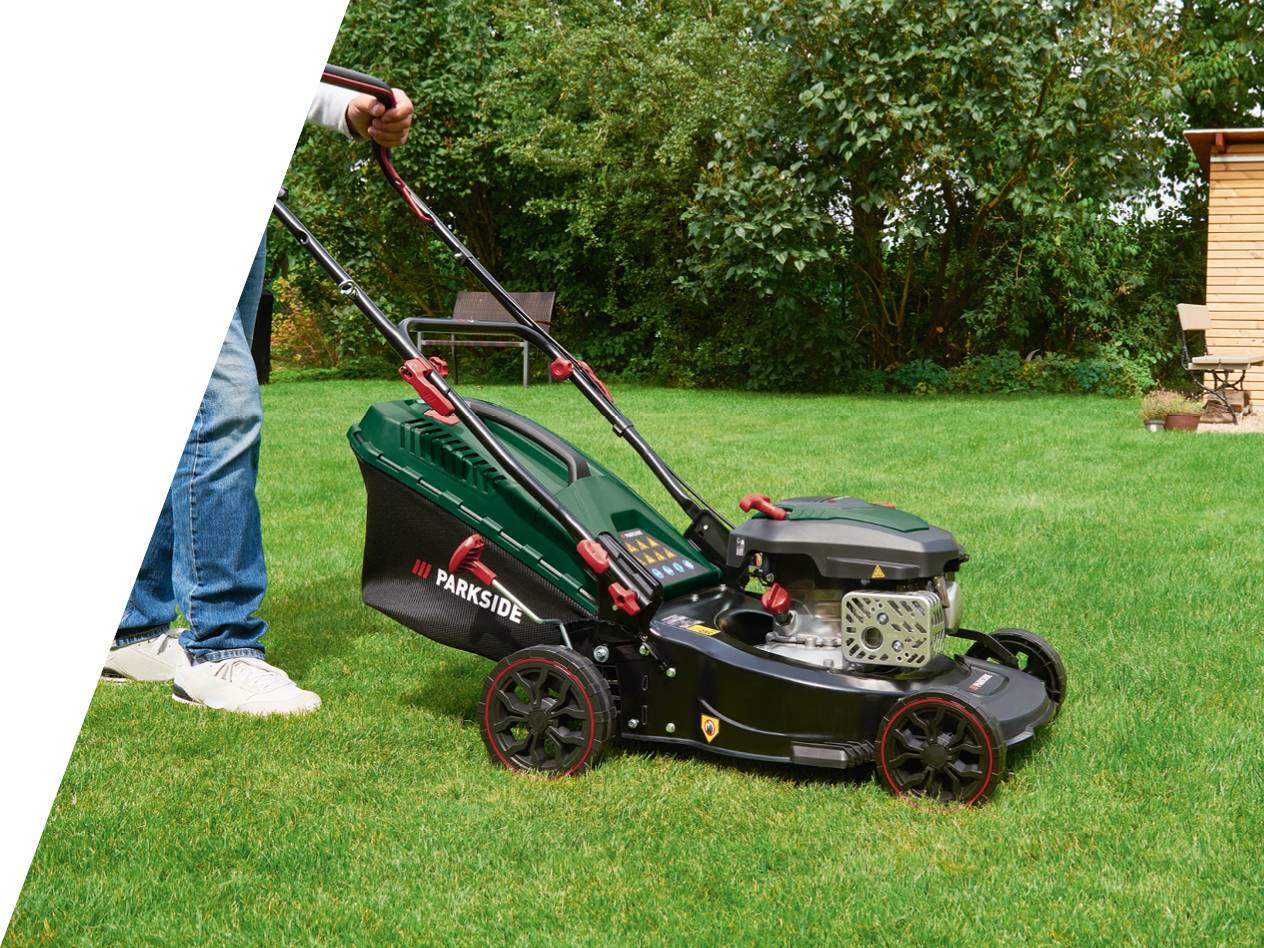 Moški kosi trato z bencinsko kosilnico Parkside.