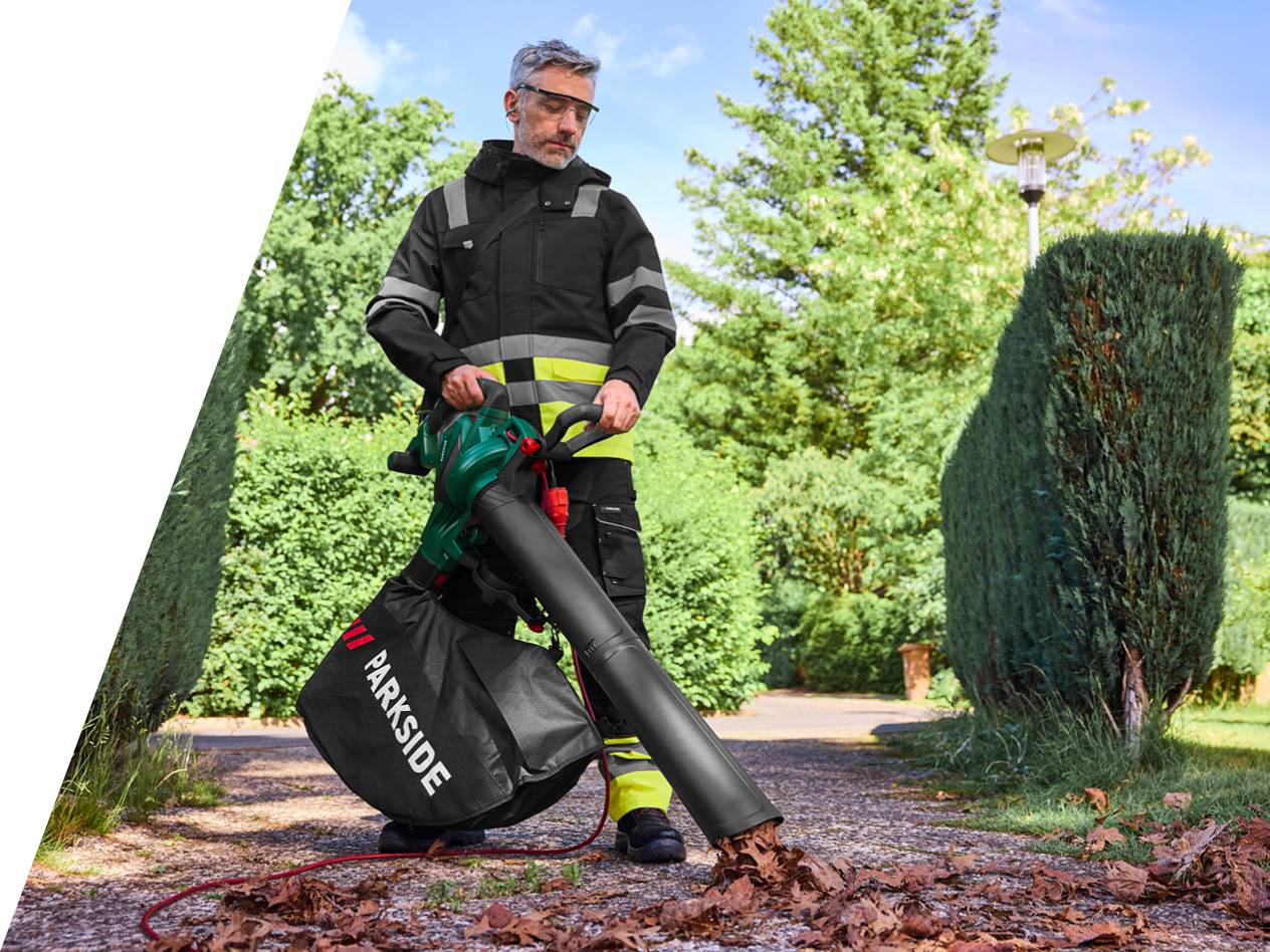 Moški uporablja Parkside pihalnik listja na vrtu.
