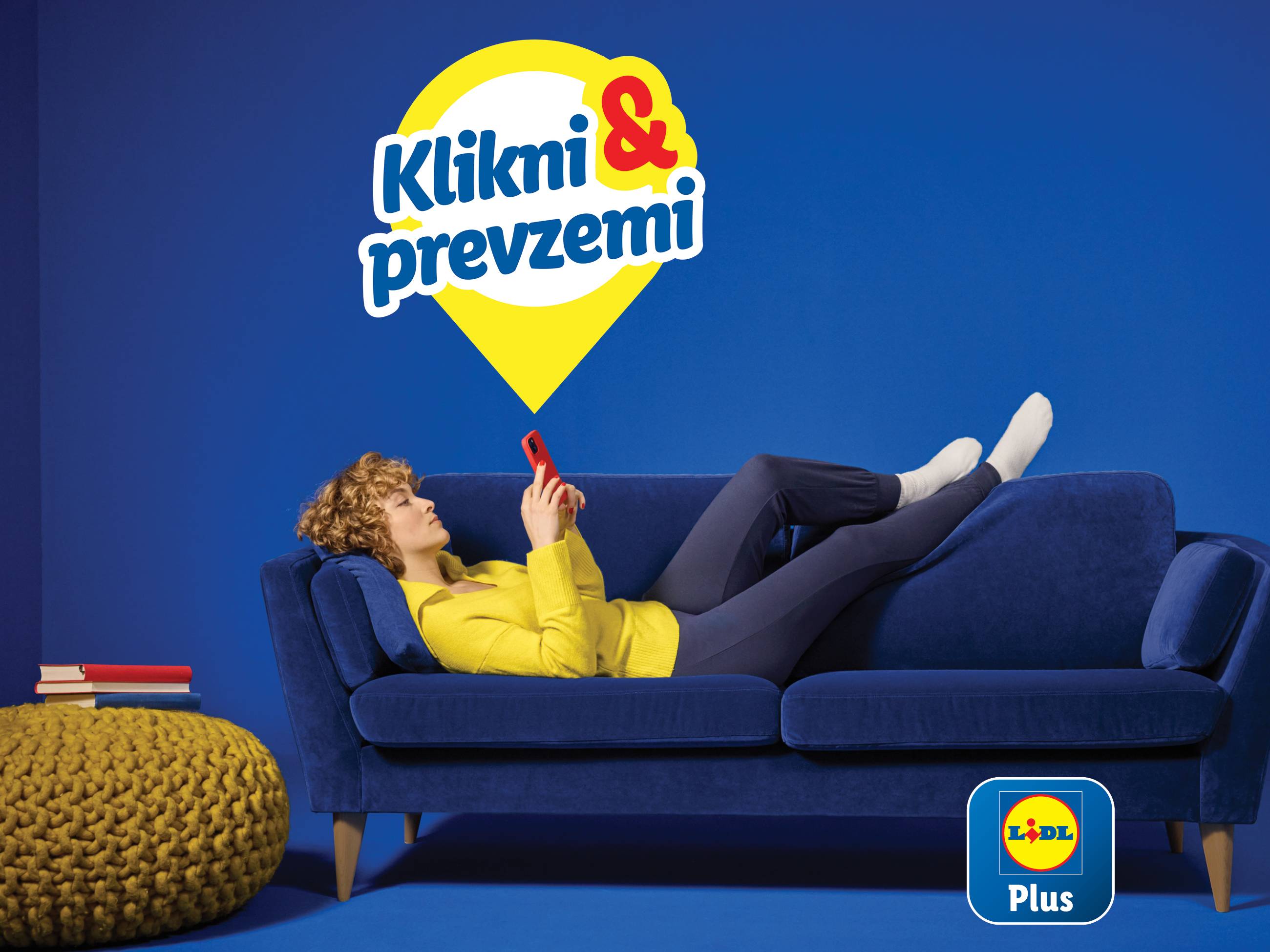 Ženska na modrem kavču uporablja Lidl Plus aplikacijo za naročilo in prevzem.